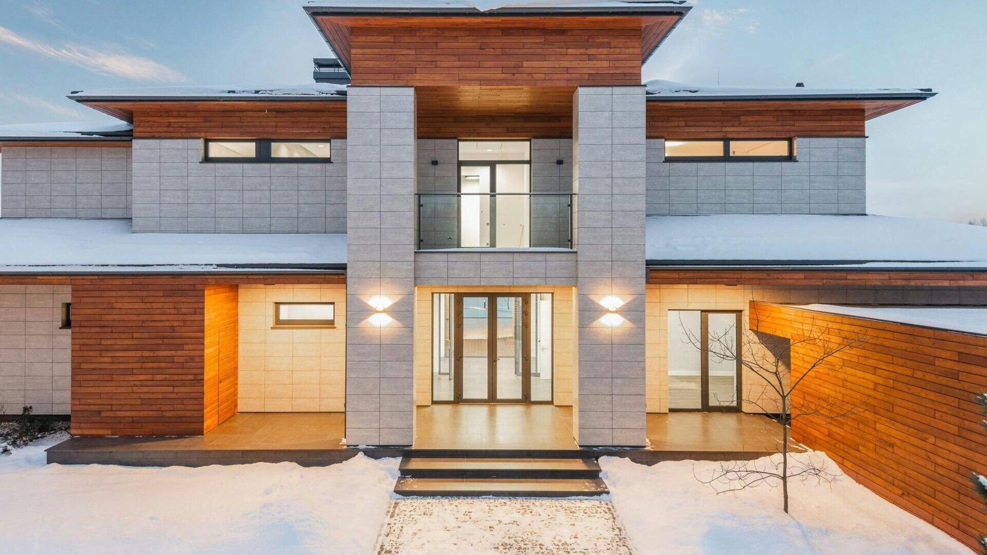 Backyard view of new modern luxurious cottage house with stone and wooden facade and illumination in winter countryside